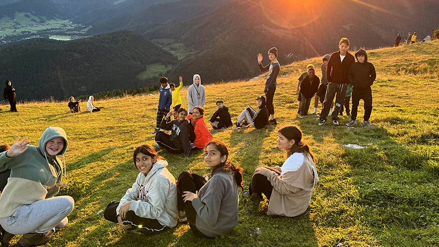 G8 students waving during a sunrise
