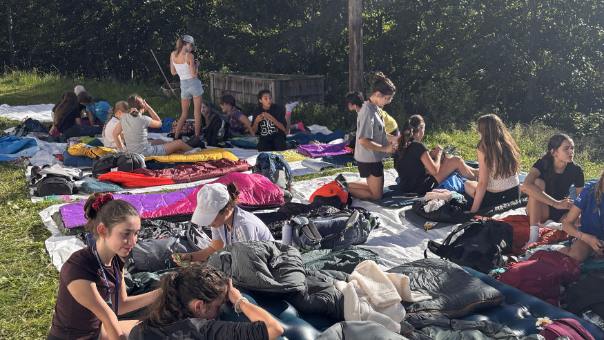 Students with sleeping bags on a lawn