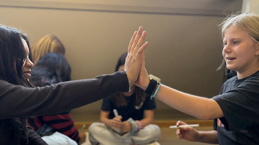 Two student giving a high five in the buddy classes